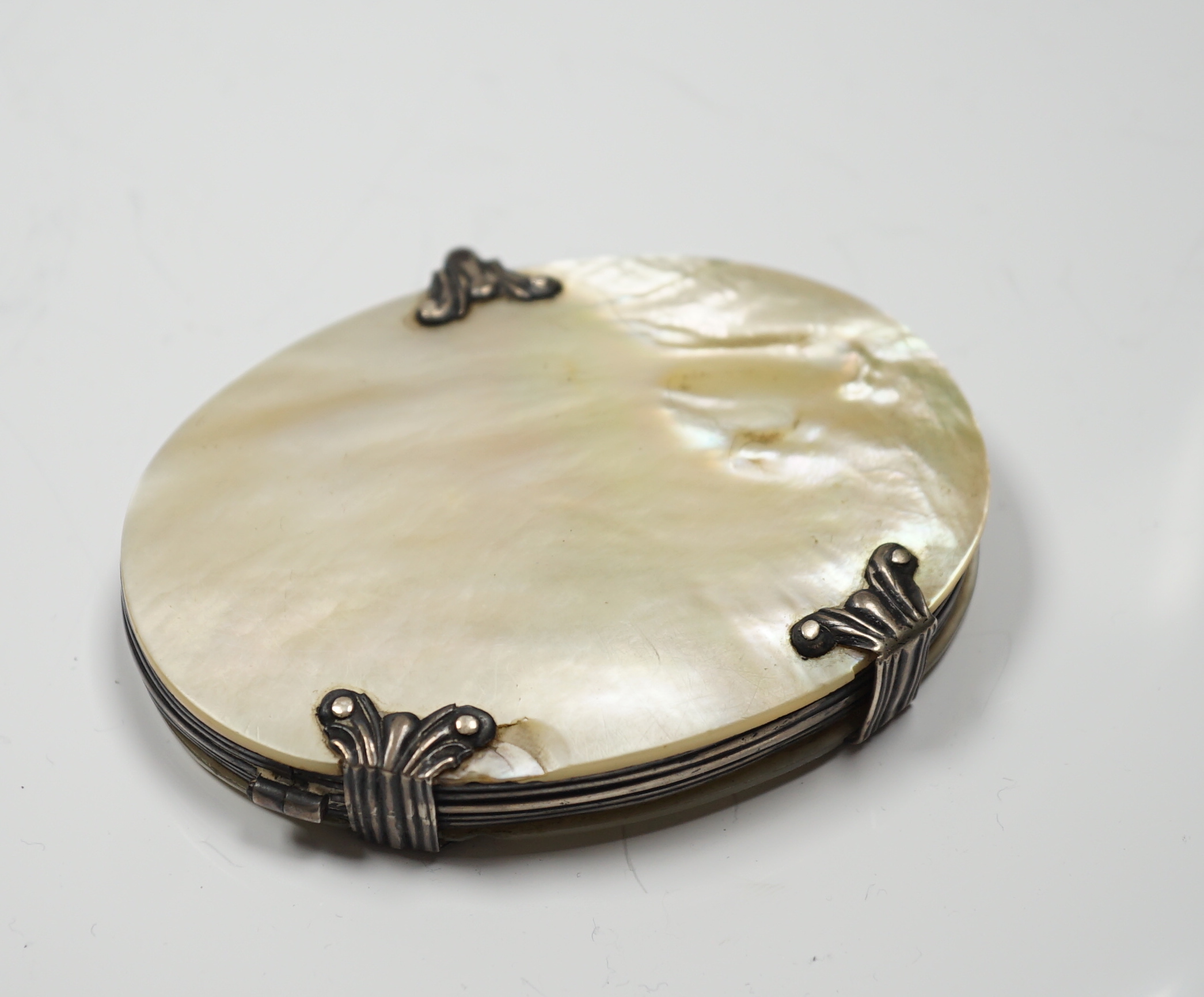A 19th century white metal and mother of pearl mounted oval folding magnifying glass (a.f.), 90mm.
